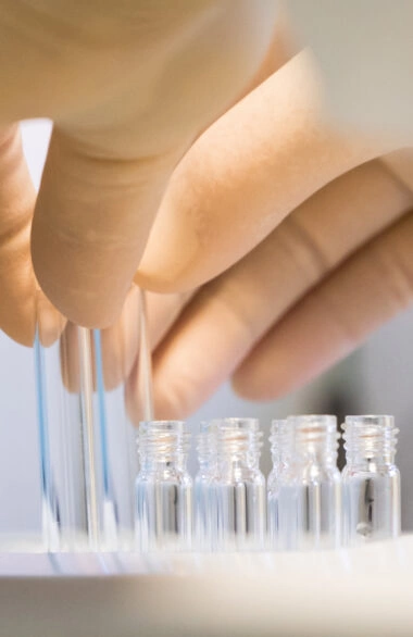 Pharmaceutical researcher handling glass vials in a laboratory